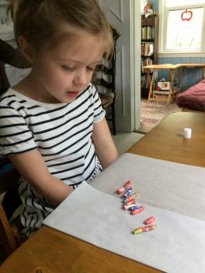 Camper looks at paper beads