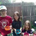 three campers hold bowls of "edible fire"