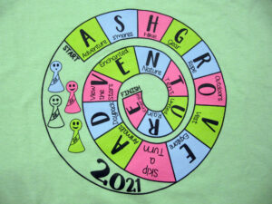 green t-shirt with a spiral of board game spaces reading Ashgrove Adventure with game pieces to one side and 2021 underneath